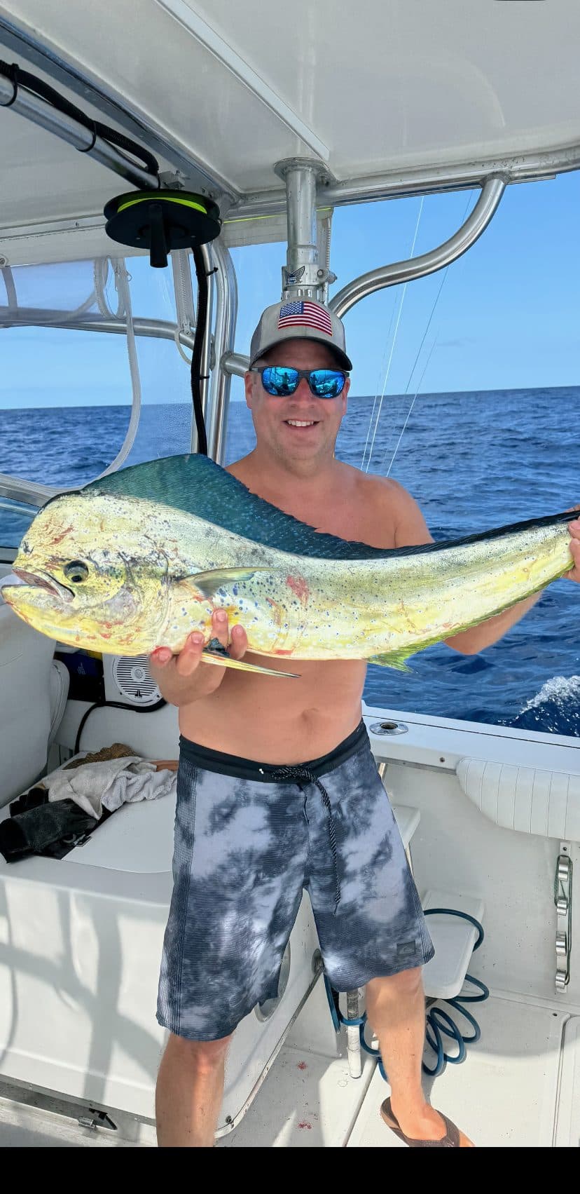 Angler holding a bull mahi on the deck offshore