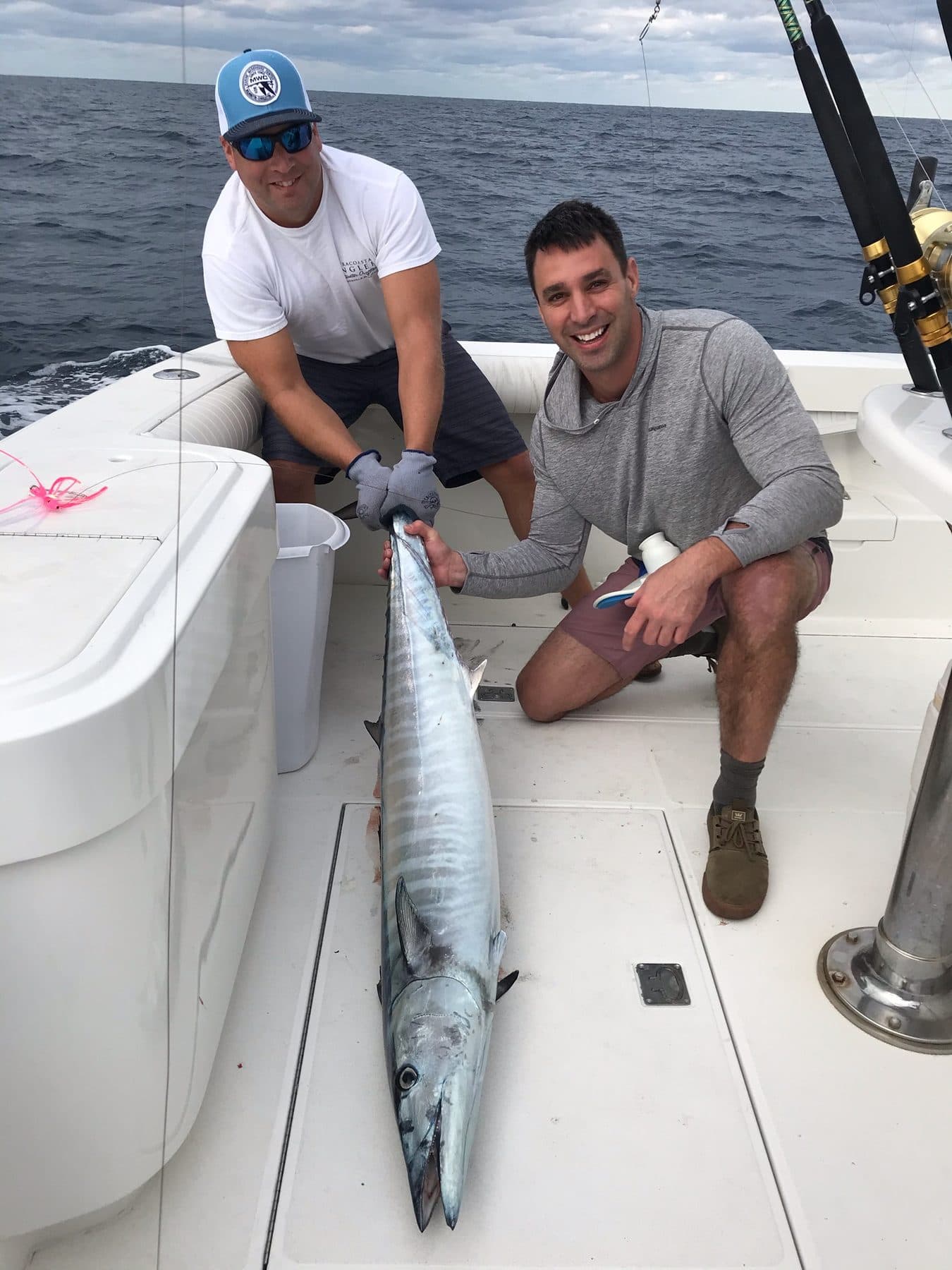 Two anglers on deck with a large wahoo